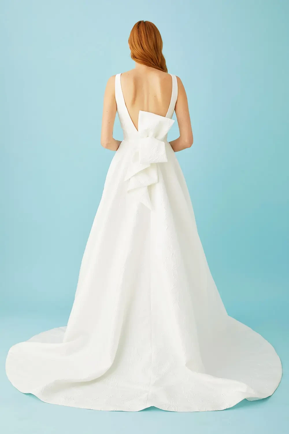 model is wearing a sleeveless minimalist wedding dress