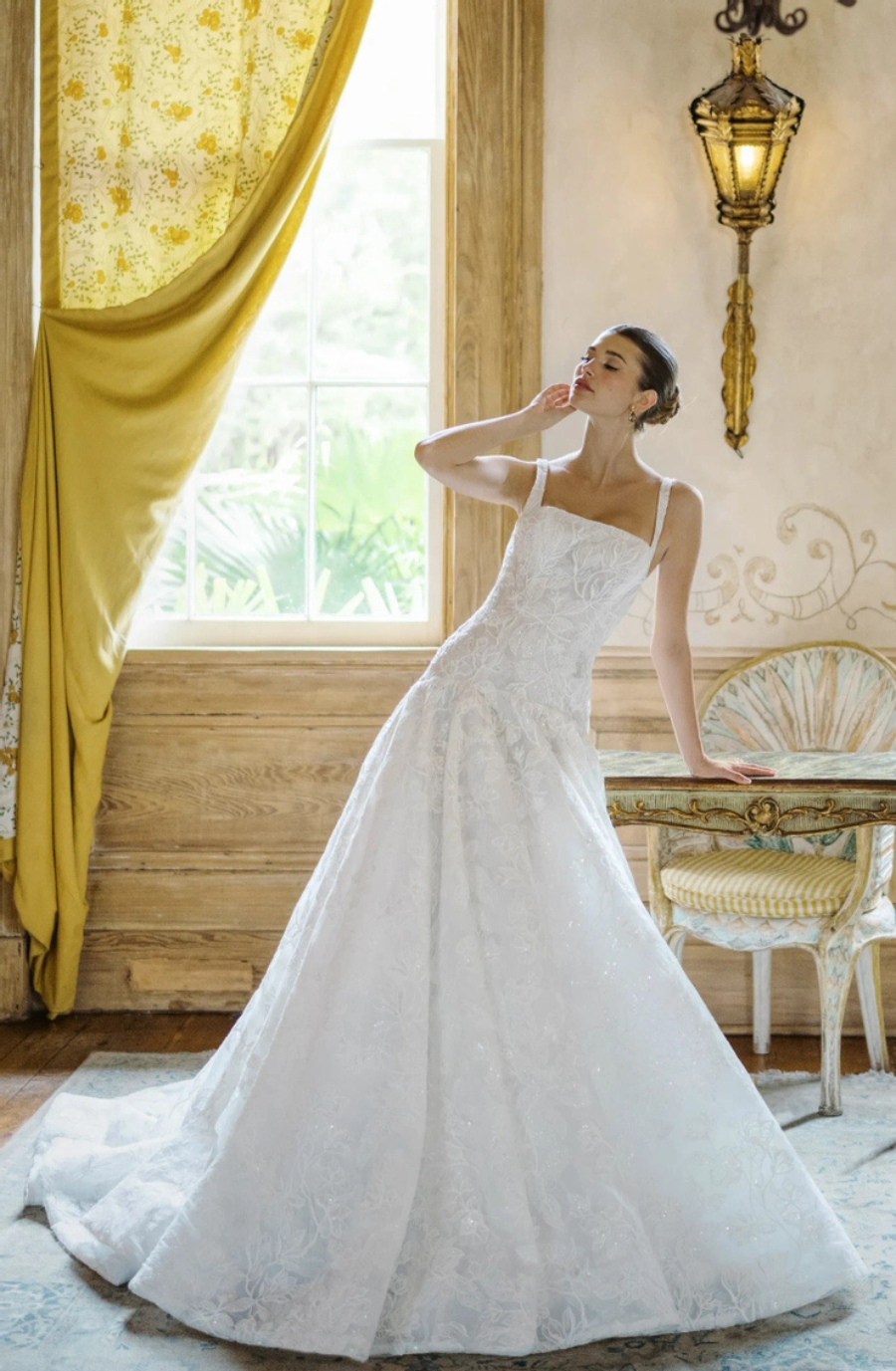 model is wearing a sleeveless a-line wedding gown with a basque waist