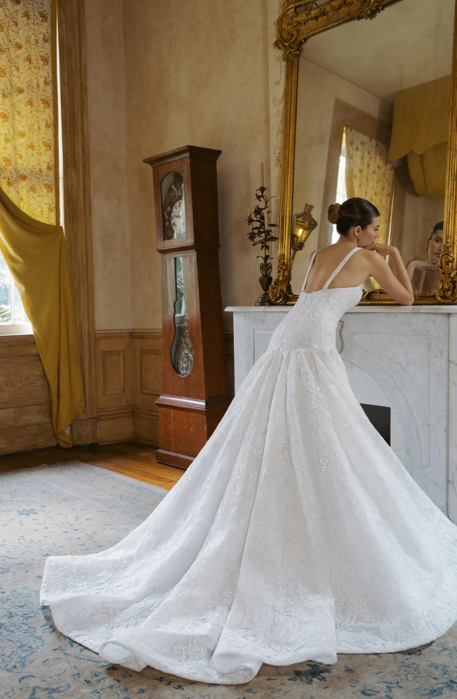 model is wearing a sleeveless a-line wedding gown with a basque waist