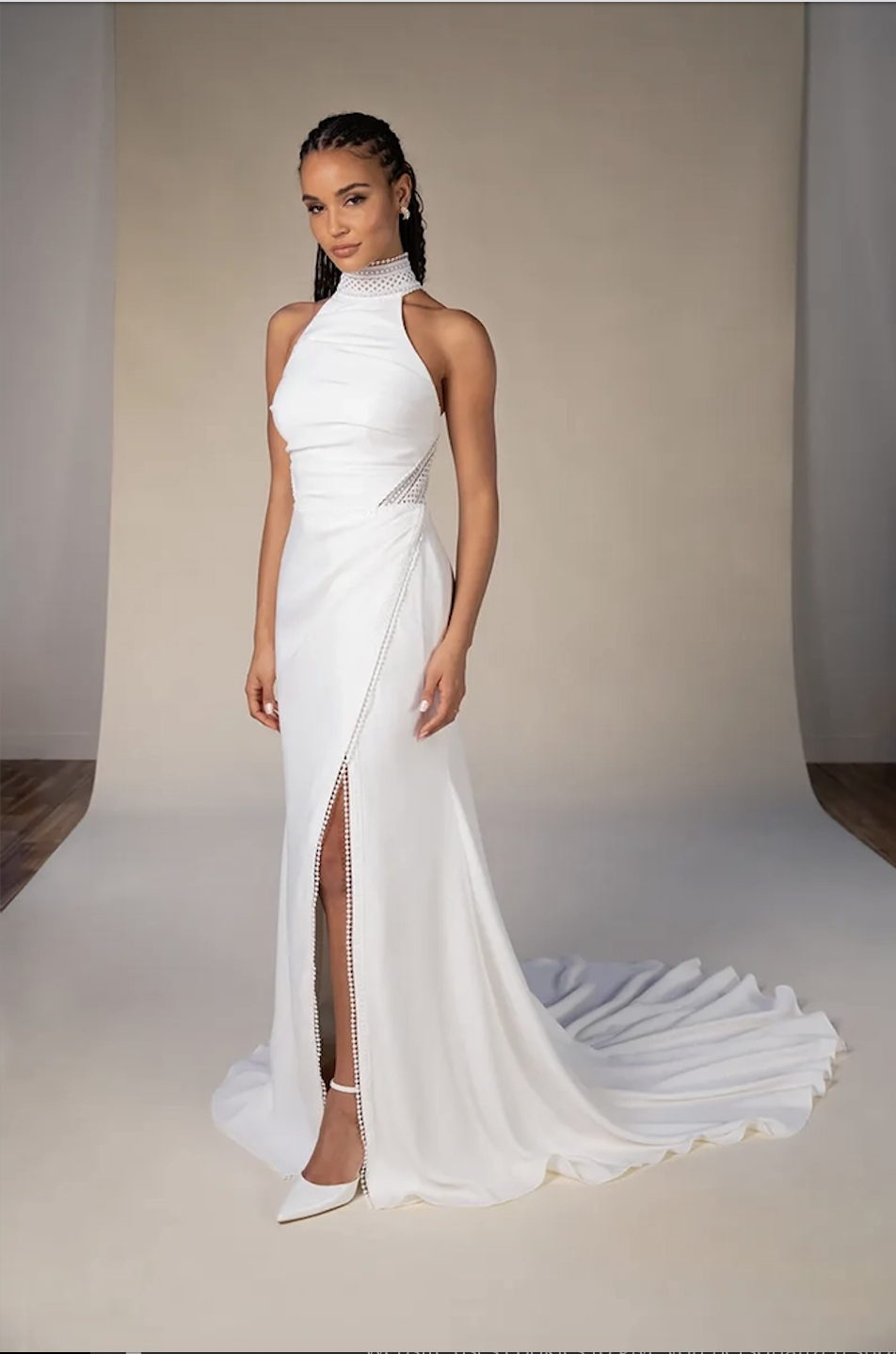 Model is wearing a halter wedding dress with a column silhouette