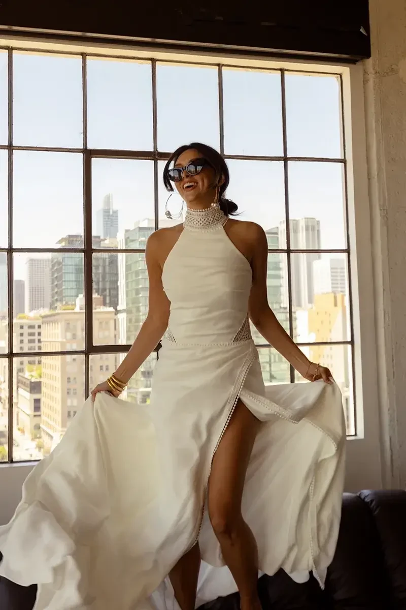 model is wearing an open back high neck halter wedding dress