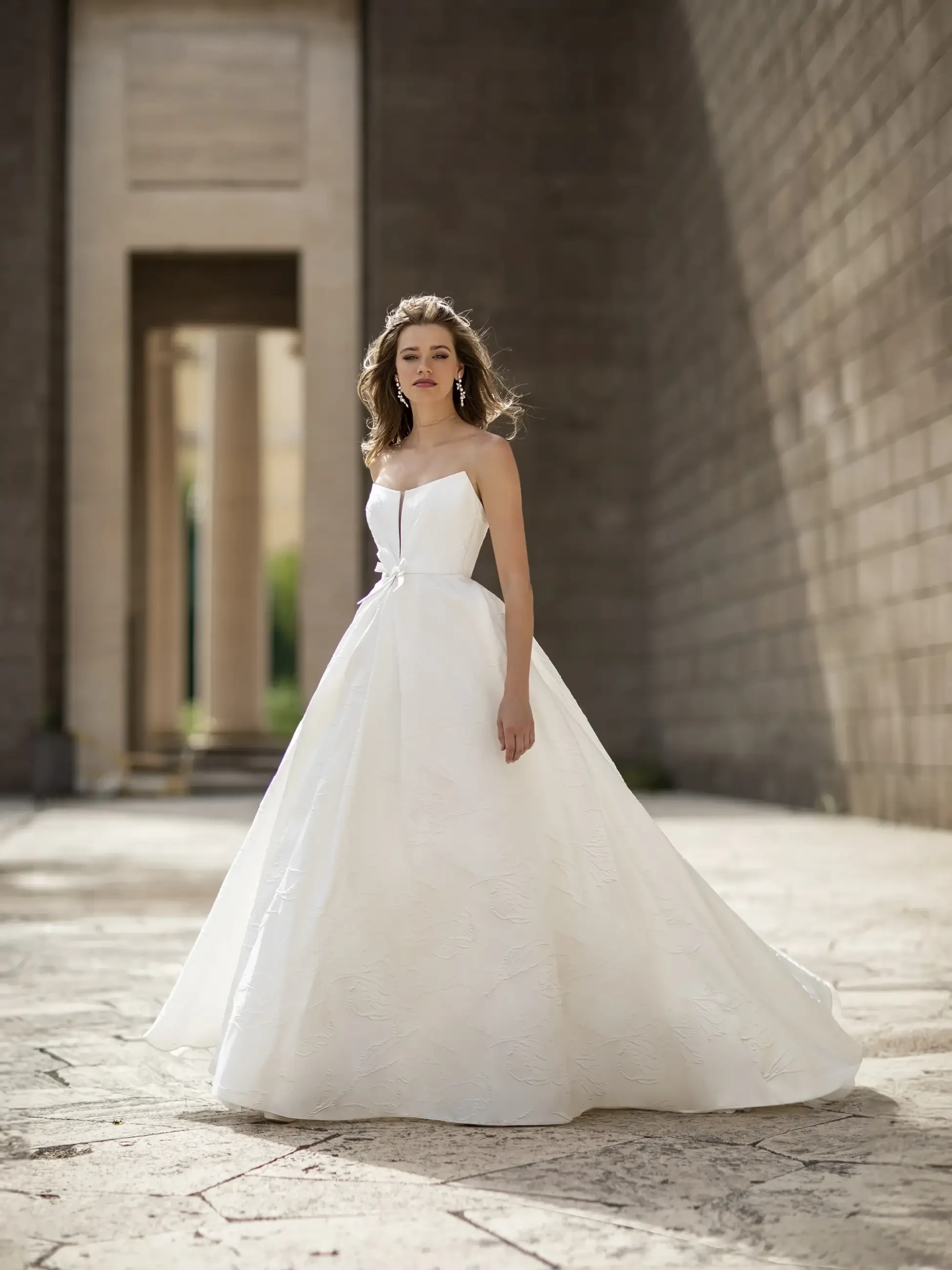 model is wearing a strapless a-line wedding dress