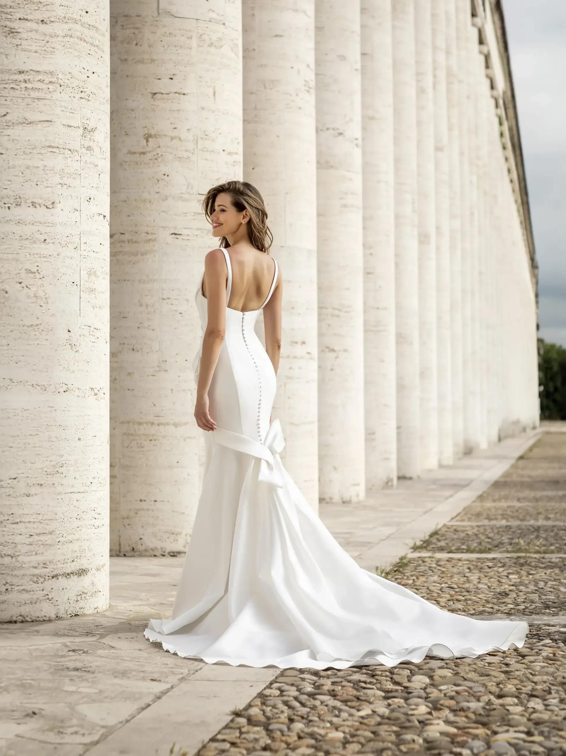 Model is wearing a sleeveless fit and flare bridal dress with a plunging neckline