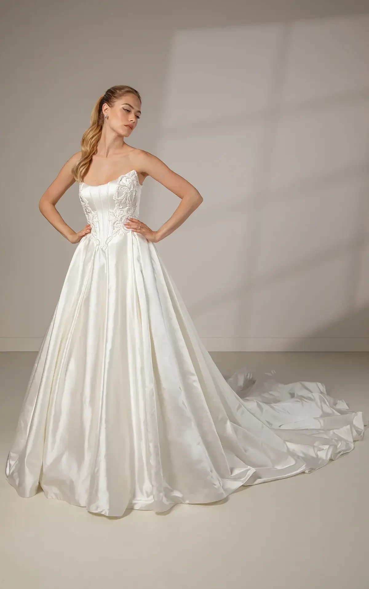 model is wearing a strapless basque waist ball gown